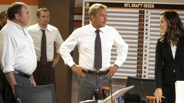 Sonny Weaver Jr. stând în fața unui panou de comandă și se uită la Ali în Ziua Draftului