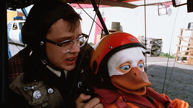 Tim Robbins ca Phil Blumburtt și Howard the Duck arată nervoși într-un cockpit din Howard the Duck