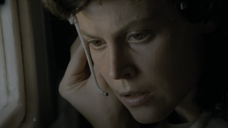 Ellen Ripley ascultă cu atenție o comunicare pe căștile ei din Alien