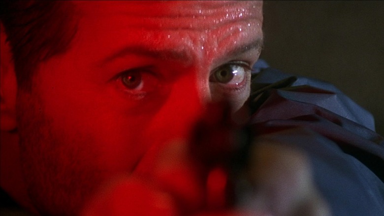 Bruce Willis în rolul lui John McClane care trage cu arma în Die Hard with a Vengeance