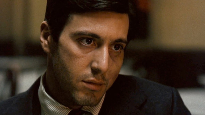 Al Pacino în rolul lui Michael Corleone, arătând intens, cu maxilarul rupt în The Godfather