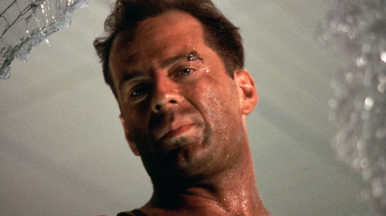 John McClane se uită printr-o fereastră spartă în Die Hard