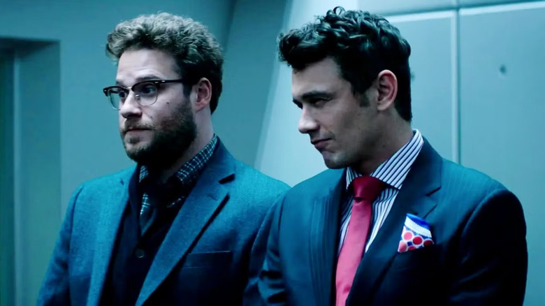 Seth Rogen și James Franco în The Interview, purtând costume și arătând suspicios