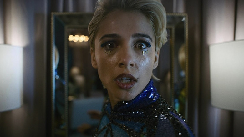 Skye Riley, purtând machiaj de scenă și un tricou, se uită direct în josul obiectivului camerei la publicul din Smile 2