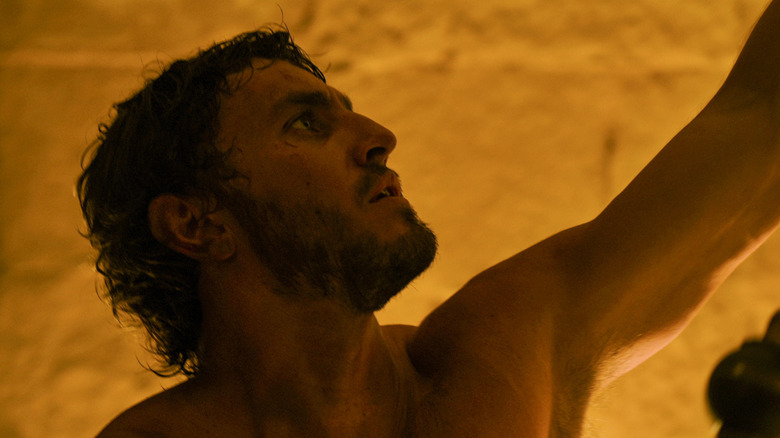 Lucius fără cămașă privind în Gladiator II