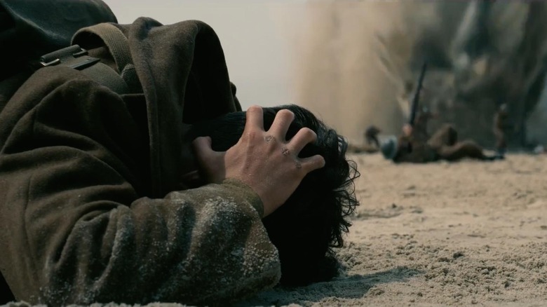 Fionn Whitehead în rolul lui Tommy care se ascunde pentru acoperire în Dunkirk