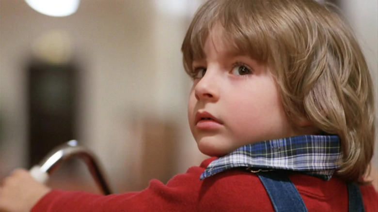Danny Torrance se uită înapoi peste umăr în The Shining