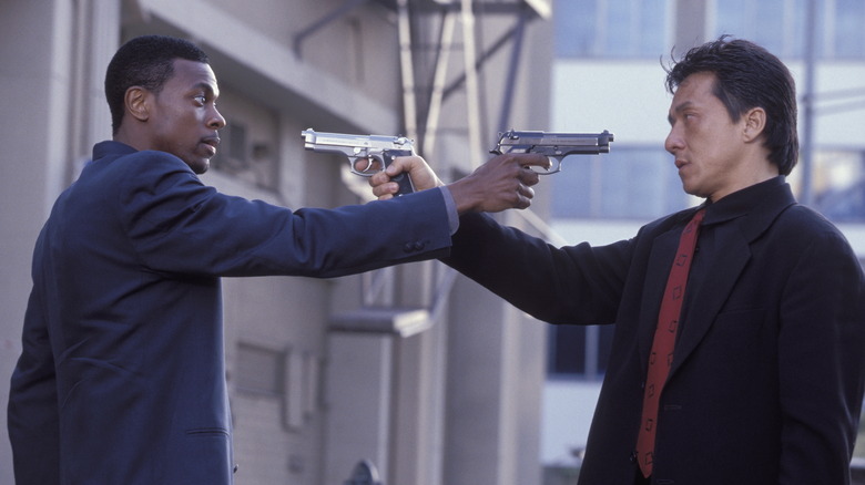 Jackie Chan în rolul inspectorului șef Lee și Chris Tucker în rolul detectivului James Carter îndreptându-se cu arme unul la altul în ora de vârf