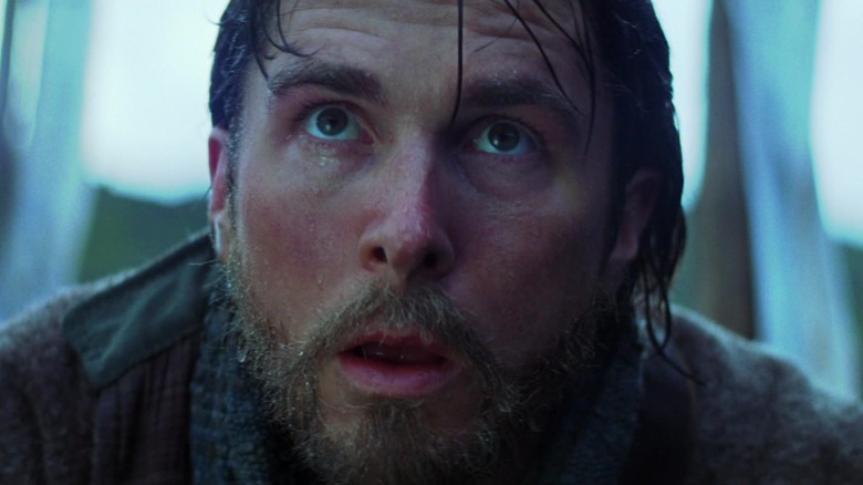 Bruce Wayne se uită surprins în Batman Begins