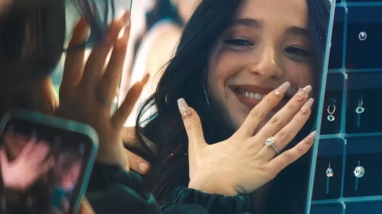 Ani își arată inelul de logodnă într-o oglindă din Anora