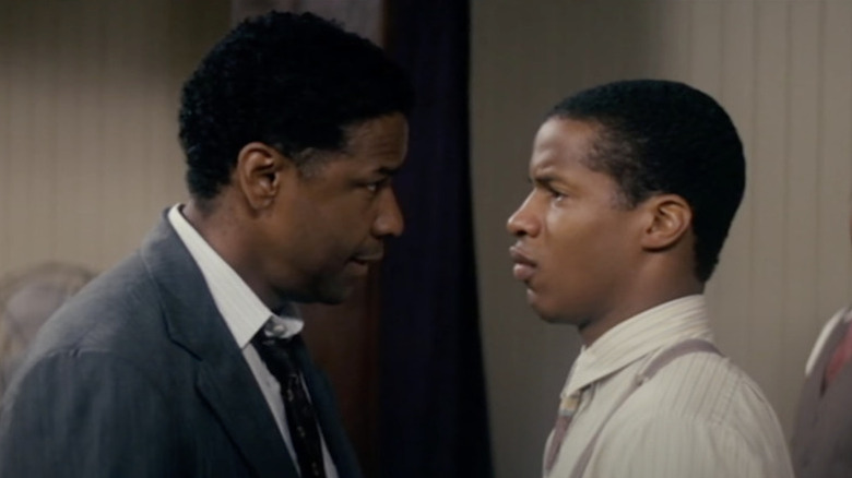 Denzel Washington în rolul profesorului Melvin Tolson și Nate Parker în rolul lui Henry Lowe, uitându-se unul la altul în The Great Debaters