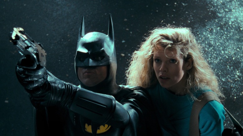 Batman își trage cârligul în timp ce Vicki Vale se uită la Batman