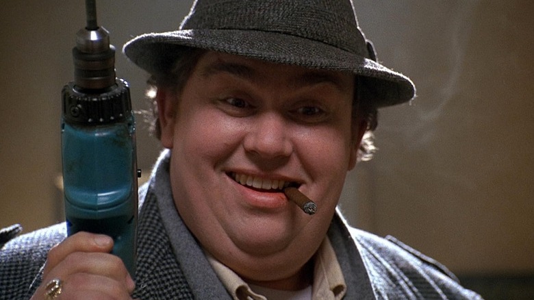 Buck Russell al lui John Candy ține un burghiu cu un trabuc în gură în Uncle Buck
