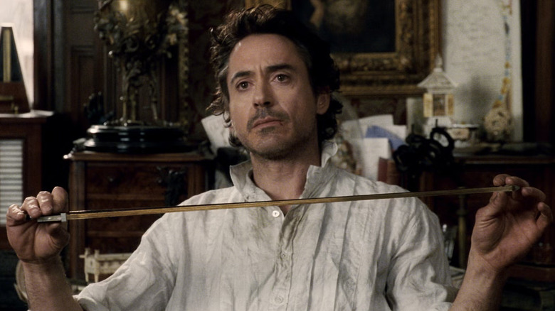 Sherlock Holmes ținând un arc de vioară