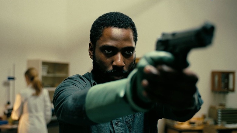 John David Washington brandește o armă de mână ca Protagonist în Tenet
