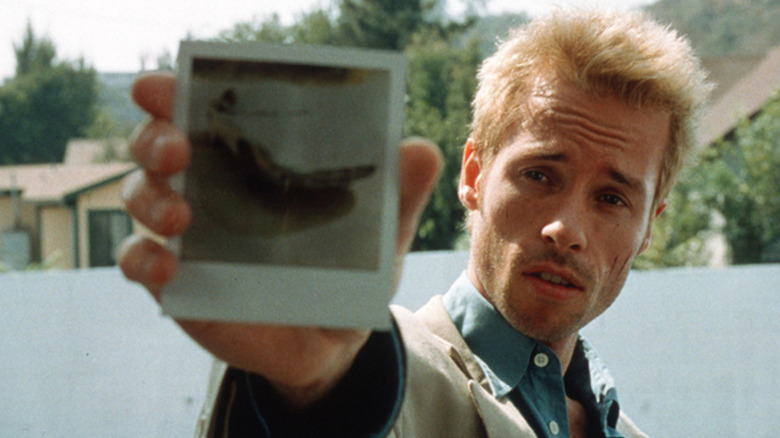 Guy Pearce ține un polaroid în rolul lui Leonard Shelby în Memento