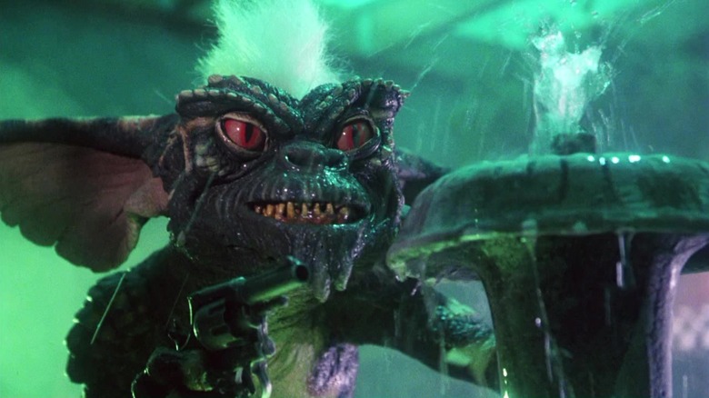 Gremlinul, Stripe, stă într-o fântână, ținând în mână un pistol