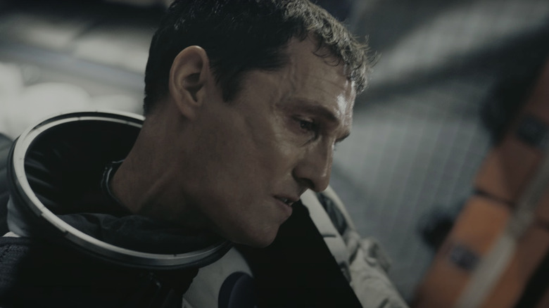 Joseph Cooper al lui Matthew McConaughey stă într-o navetă spațială privind în jos în Interstellar