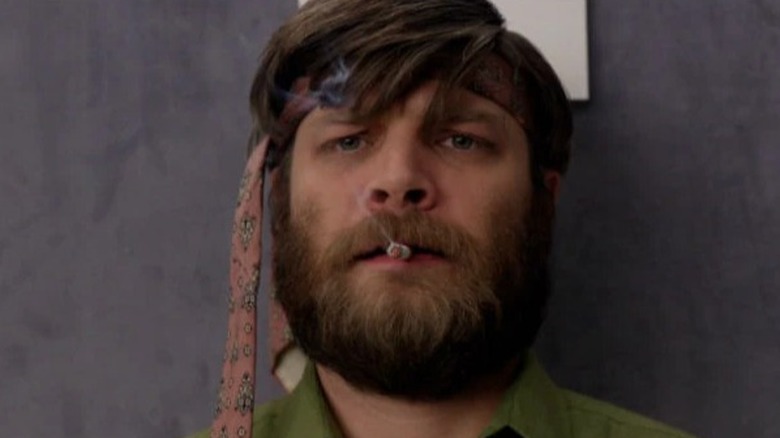 Stan Rizzo din Mad Men fumează cu o cravată înfășurată în jurul capului