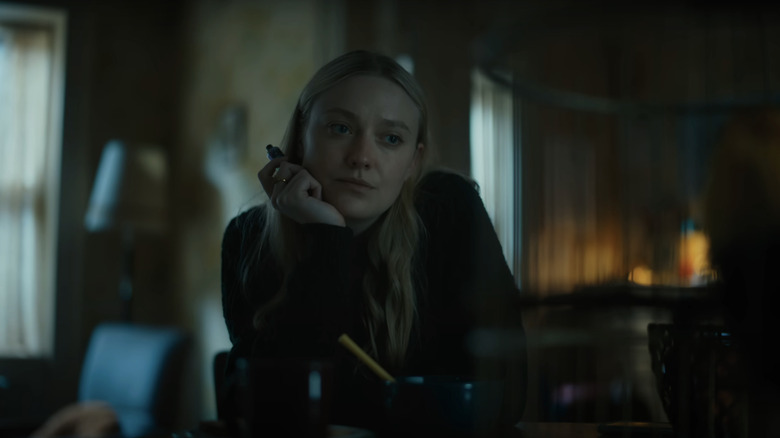 Mina/Lucy a lui Dakota Fanning stă într-o cameră de zi din The Watchers