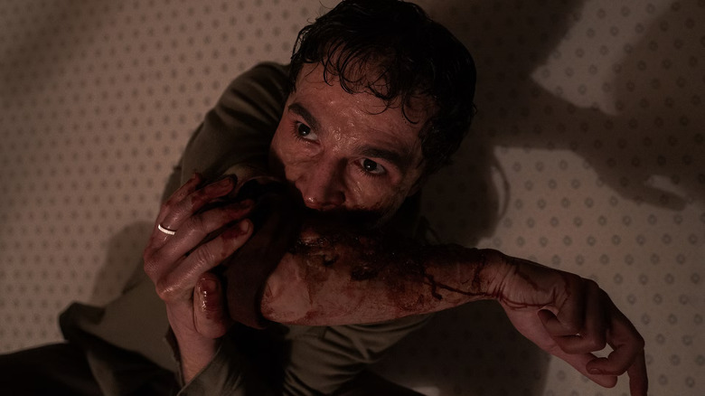 Blake, mestecându-și propriul braț ca... ei bine, ca un Wolf Man în Wolf Man