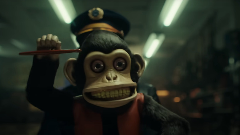 Cineva ține în mână păpușa maimuță blestemata din The Monkey