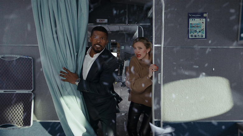 Matt din Jamie Foxx și Emily din Cameron Diaz stau într-un avion în timp ce sticlă spartă se învârte în jurul lor în Back in Action
