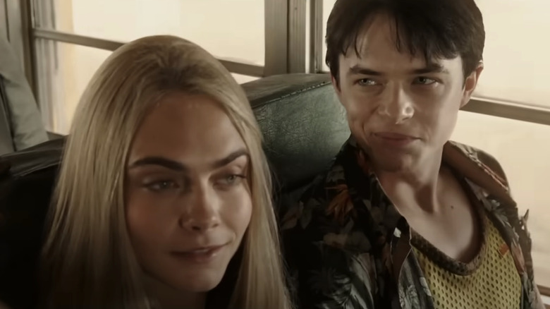 Valerianul lui Dane DeHaan și Laurelineul lui Cara Delevingne stau unul lângă altul într-un autobuz în Valerian și Orașul O Mie de Planete