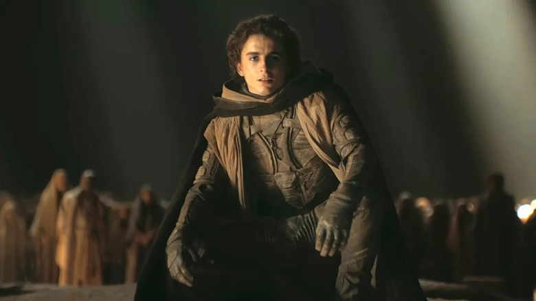 Paul se ghemui în fața unui grup de fremeni în Dune: Part Two