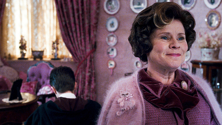Umbridge zâmbind în biroul ei în timp ce Harry scrie rânduri în Harry Potter și Ordinul Phoenix