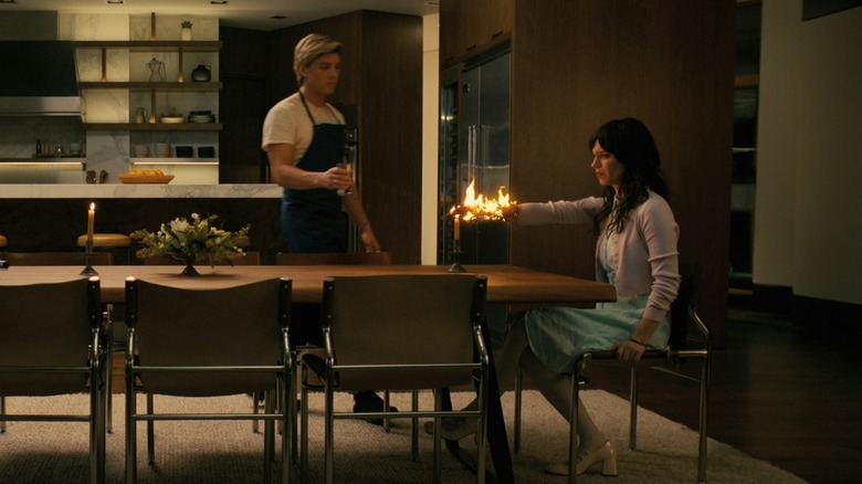 Lukas Gage în timp ce Patrick aduc apă pentru a scoate focul care arde pe brațul irisului lui Sophie Thatcher în însoțitor