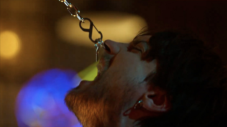 Artistul de tatuaj fiind ținut de un lanț în destinația finală: linii de sânge