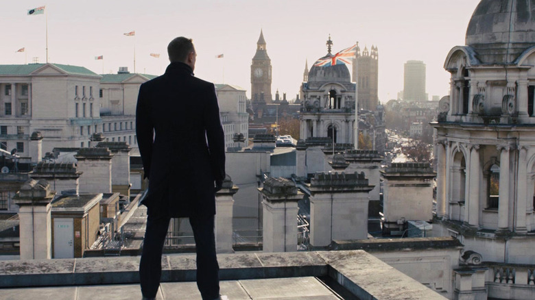 James Bond de la Daniel Craig se află pe un acoperiș din Londra cu vedere la oraș, cu union Jack vizibil în Skyfall