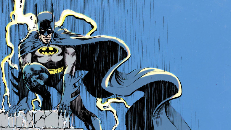 Batman stând pe acoperiș în timp ce lovește fulgere