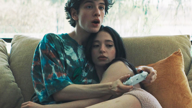 Ivan Zakharovthe, Mark Eydelshteyn și Mikey Madison, se așează împreună pe o canapea în timp ce Ivan joacă jocuri video în Anora