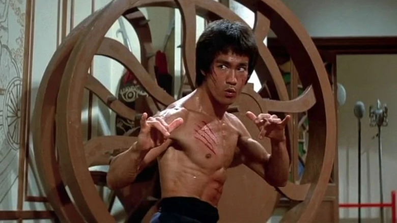 Bruce Lee ca Lee fără cămașă și stând defensiv în Enter the Dragon