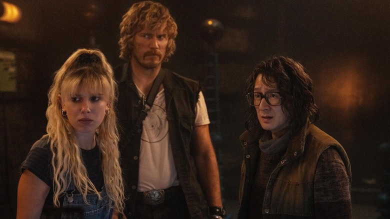Chris Pratt ca John D. Keats și Millie Bobby Brown ca Michelle Greene în picioare cu Ke Huy Quan în rolul Dr. Clark Amherst în statul electric