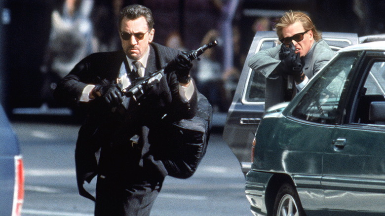 Neilul lui Robert De Niro care alerga pe stradă, în timp ce Chris -ul lui Val Kilmer îl acoperă în timpul schimbului de foc în căldură