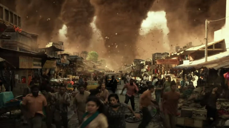 Oamenii intră în panică pe o stradă a orașului, în timp ce mai multe tornade se apropie de fundal în Geostorm