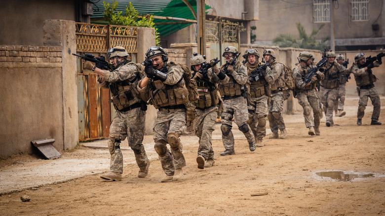 Charles Melton în rolul lui Jake conducând o echipă de soldați puternic armate pe străzile Irakului în război