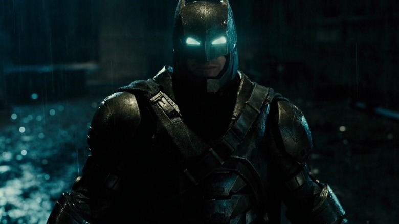 Ben Affleck în rolul lui Batman în costumul său de metal mergând în ploaie în Batman v Superman: Dawn of Justice
