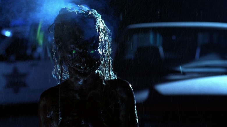 Un demon care stă în afara casei în ploaie în povești din criptă: Demon Knight