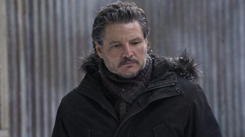 Joel în zăpadă într -o haină privind în jos în ultimul dintre noi