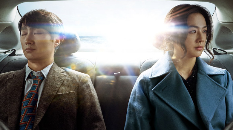 Park Hae-Il ca Hae-Jun și Tang Wei ca Seo-rae stând unul lângă celălalt în bancheta din spate a unei mașini în decizie de a pleca