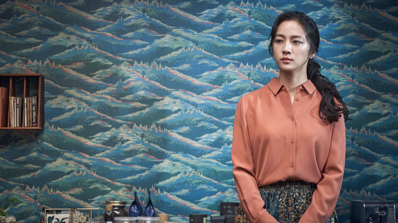 Tang Wei ca Song Seo-Rae în picioare pe un perete în decizie de a pleca