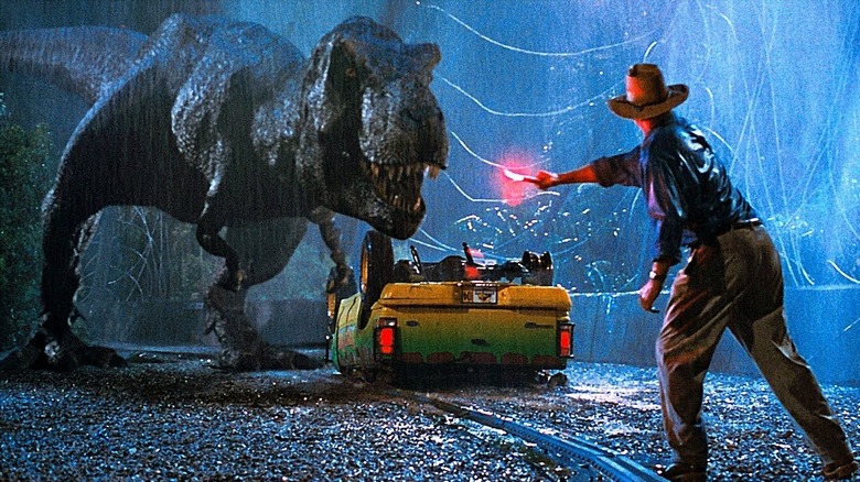 Dr. Grant își face o flacără în fața unui T-Rex în ploaie în Jurassic Park