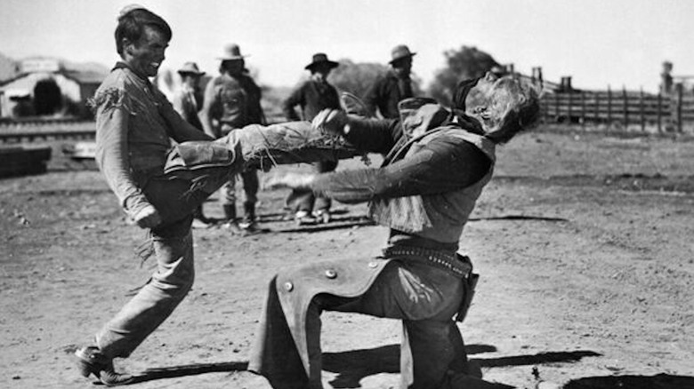 Montgomery Clift în timp ce Matt Garth îl lovește pe John Wayne în rolul lui Thomas Dunson în fața Râului Roșu în față