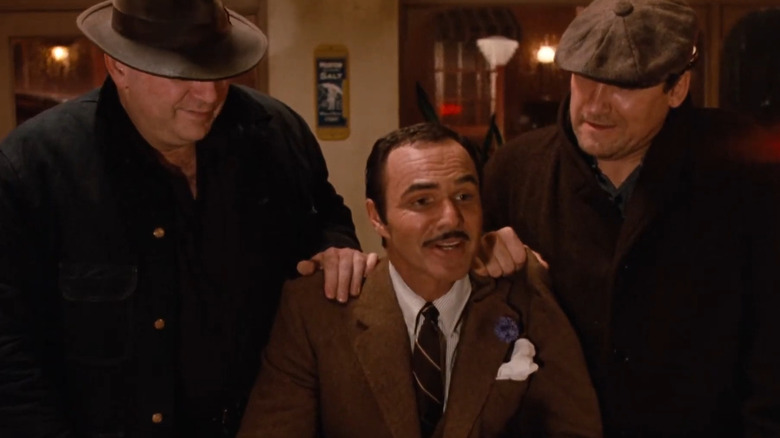 Murphy stând la un restaurant cu două capre în spatele lui în căldura orașului