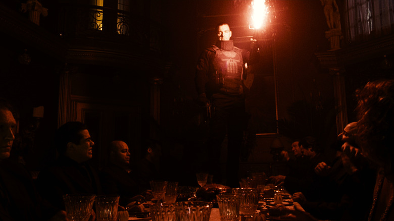 Frank Castle care stă pe o masă care ținea o flacără roșie în Punisher: Zona de război