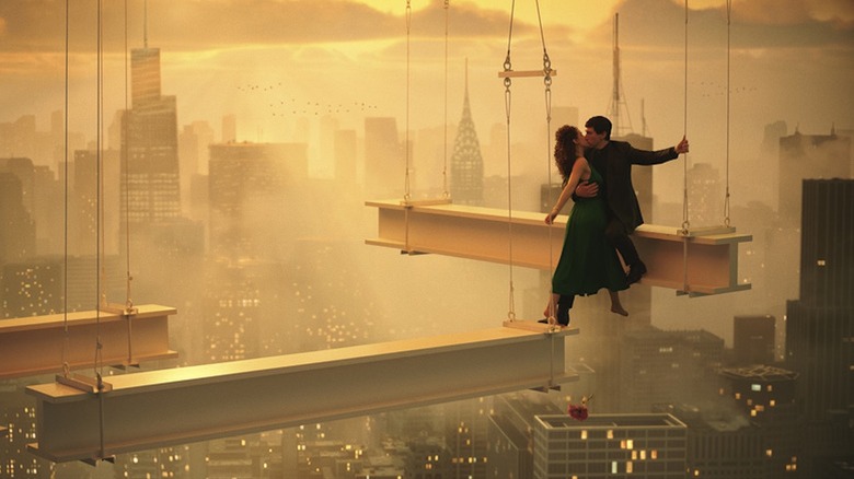 Adam Driver ca Cesar Catalina și Nathalie Emmanuel în rolul lui Julia Cicero împărtășesc un sărut deasupra noii Roma în Megalopolis